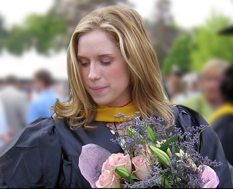 Photo of Kristin Mitchell in graduation gown with flowers